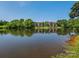 Scenic view of condo buildings overlooking a tranquil lake with lush green trees at 8208 Cedar Glen Dr, Charlotte, NC 28212