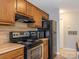 Compact kitchen features all black appliances and lots of wood cabinetry for extra storage space at 8208 Cedar Glen Dr, Charlotte, NC 28212