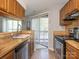 Practical kitchen features wood cabinetry, a stainless steel dishwasher, and a view to the porch at 8208 Cedar Glen Dr, Charlotte, NC 28212