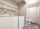 Bright laundry room with washer, dryer, and storage shelves at 8208 Cedar Glen Dr, Charlotte, NC 28212
