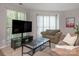Cozy living room featuring a comfortable sofa, entertainment center, and bright windows at 8208 Cedar Glen Dr, Charlotte, NC 28212