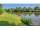 Picturesque view of a serene lake framed by lush greenery on the shore at 8208 Cedar Glen Dr, Charlotte, NC 28212