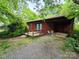 Exterior view of the rustic home with a covered patio and wooded surroundings at 823 Corbin St, Albemarle, NC 28001