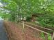 A sideyard is lined by a rustic wooden fence alongside the house and street at 823 Corbin St, Albemarle, NC 28001