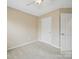 A bright and neutral bedroom with white trim and a large door and closet at 9564 Kings Parade Blvd, Charlotte, NC 28273