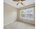 This bedroom features neutral carpeting, a ceiling fan, and a large window for natural light at 9564 Kings Parade Blvd, Charlotte, NC 28273