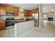 This updated kitchen has stainless appliances, wood cabinets, and is adjacent to the living room at 9564 Kings Parade Blvd, Charlotte, NC 28273