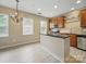 Bright kitchen features stainless steel appliances, wood cabinets, and an island with a black countertop at 9564 Kings Parade Blvd, Charlotte, NC 28273