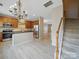 Open concept kitchen with stainless steel appliances, wood cabinets, island, and staircase access at 9564 Kings Parade Blvd, Charlotte, NC 28273