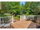 Relax on this spacious back deck with white railing and enjoy the lush greenery and wooded backyard at 102 Rosewood Ln, Locust, NC 28097