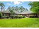 Expansive backyard features a well-maintained lawn, mature trees, and manicured landscaping, creating a serene outdoor oasis at 102 Rosewood Ln, Locust, NC 28097