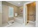 Bright bathroom featuring a tub with tiled surround, and separate tiled shower at 102 Rosewood Ln, Locust, NC 28097