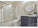 Stylish bathroom with a glass shower, patterned tile floor, and a navy vanity with a round mirror at 102 Rosewood Ln, Locust, NC 28097