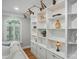 Elegant built-in shelves adorned with decorative items and stylish lighting, adjacent to a large window with plantation shutters at 102 Rosewood Ln, Locust, NC 28097