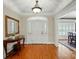 Elegant foyer featuring hardwood floors, a stylish console table with a mirror, and an arched doorway to a dining room at 102 Rosewood Ln, Locust, NC 28097