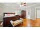 Spacious primary bedroom with tray ceiling, a sitting area, and hardwood floors at 102 Rosewood Ln, Locust, NC 28097