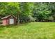 Charming storage shed nestled in a lush backyard with beautiful landscaping and mature trees for privacy at 102 Rosewood Ln, Locust, NC 28097