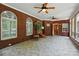 Sun room with brick walls, tile floor, ceiling fans, and multiple windows for natural light at 102 Rosewood Ln, Locust, NC 28097