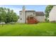 Expansive backyard featuring a wooden deck, mature trees, and well-maintained lawn at 10306 Madison Park Dr, Charlotte, NC 28269