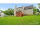 A well-maintained backyard with lush green grass, a wooden deck, and beautiful natural light at 10306 Madison Park Dr, Charlotte, NC 28269