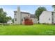View of a backyard featuring a well-kept lawn and a charming wooden deck with a shaded canopy at 10306 Madison Park Dr, Charlotte, NC 28269