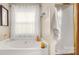 Bathroom with a tub, shower, bright window, and decorative towel rack at 10306 Madison Park Dr, Charlotte, NC 28269