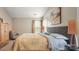 This bedroom has a large window with blinds and curtains and a patterned bedspread and decorative headboard at 10306 Madison Park Dr, Charlotte, NC 28269