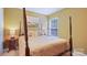 Bedroom featuring a four poster bed, side table, and bright window at 10306 Madison Park Dr, Charlotte, NC 28269