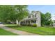 Charming two-story home with a manicured lawn, mature trees, and inviting front porch at 10306 Madison Park Dr, Charlotte, NC 28269