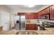 Well-lit kitchen featuring stainless steel appliances, granite countertops, and dark wood cabinetry at 10306 Madison Park Dr, Charlotte, NC 28269