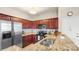 Well-lit kitchen features stainless steel appliances, granite countertops, and beautiful wood cabinetry at 10306 Madison Park Dr, Charlotte, NC 28269
