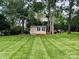 Well-maintained backyard with a storage shed, mature trees, and meticulously striped lawn at 104 Laura Ct, Cherryville, NC 28021
