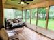 Relaxing sunroom with comfortable seating, wood flooring, and large windows overlooking the yard at 104 Laura Ct, Cherryville, NC 28021
