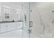 Modern bathroom with glass shower, white cabinets, and white marble flooring at 105 Pelican Ct, Mooresville, NC 28117