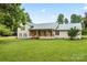 Charming home featuring a covered front porch, a manicured lawn, and beautiful landscaping at 105 Pelican Ct, Mooresville, NC 28117
