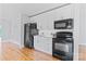 Modern kitchen features black appliances, sleek white cabinets, and beautiful hardwood floors at 105 Pelican Ct, Mooresville, NC 28117