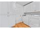 Well-organized laundry room features modern washer, dryer, white cabinetry, and wooden floors at 105 Pelican Ct, Mooresville, NC 28117