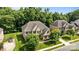 An aerial shot shows the charming brick home with a well-manicured lawn, and tree-lined street at 10508 Kristens Mare Dr, Charlotte, NC 28277