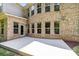 Large concrete patio featuring a door to the house surrounded by brick walls and multiple windows at 10508 Kristens Mare Dr, Charlotte, NC 28277