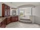 Elegant bathroom featuring a soaking tub with tiled surround, custom cabinetry, and a granite countertop at 10508 Kristens Mare Dr, Charlotte, NC 28277