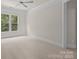 Light-filled bedroom featuring a ceiling fan, plush carpeting, and a view of nature through the double windows at 10508 Kristens Mare Dr, Charlotte, NC 28277