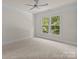Bright, airy bedroom with a ceiling fan, neutral carpet, and plenty of natural light from the double windows at 10508 Kristens Mare Dr, Charlotte, NC 28277