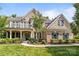 Beautiful brick home featuring a front porch, second-story balcony, and well-manicured lawn at 10508 Kristens Mare Dr, Charlotte, NC 28277