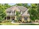 Beautiful brick home featuring a front porch, second-story balcony, and well-manicured lawn at 10508 Kristens Mare Dr, Charlotte, NC 28277