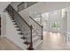 Grand foyer showcasing hardwood floors, a staircase with decorative iron spindles, and a high ceiling with a chandelier at 10508 Kristens Mare Dr, Charlotte, NC 28277