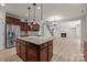 Open kitchen with island, stainless steel appliances, granite countertops, and hardwood floors view to the living room at 10508 Kristens Mare Dr, Charlotte, NC 28277