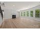 Bright living room featuring a fireplace, hardwood floors, and multiple windows with natural light at 10508 Kristens Mare Dr, Charlotte, NC 28277