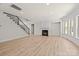 Open living room with hardwood floors, fireplace, staircase, and plenty of natural light from large windows at 10508 Kristens Mare Dr, Charlotte, NC 28277