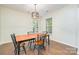 Bright dining area features hardwood floors, a modern chandelier, and plentiful natural light from large windows at 10732 Trolley Run Dr, Cornelius, NC 28031