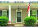 Charming home showcasing a covered front porch, complemented by well-maintained landscaping and an American flag at 10732 Trolley Run Dr, Cornelius, NC 28031